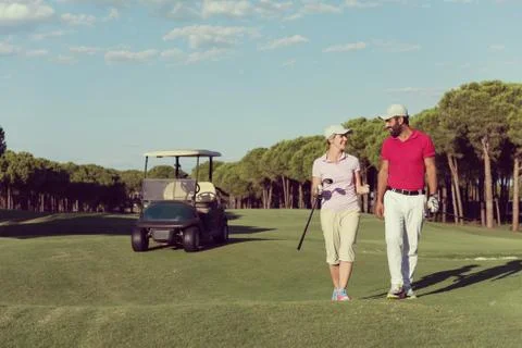 Couple walking on golf course Fotos Stock