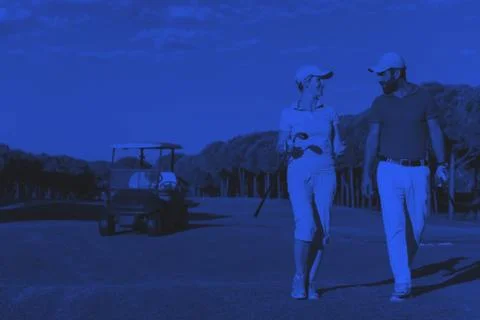 Couple walking on golf course Fotos Stock