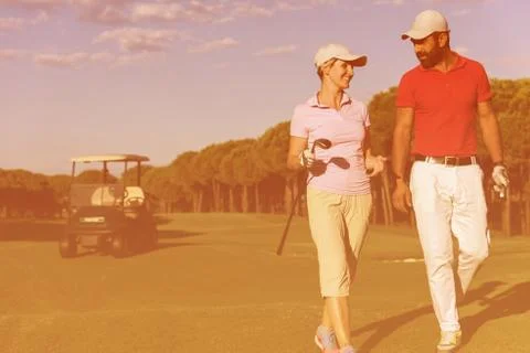 Couple walking on golf course Fotos de archivo