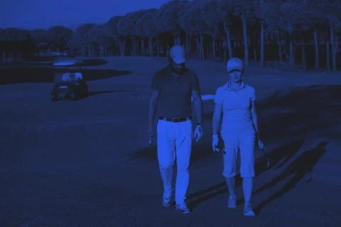 Couple walking on golf course Fotos de archivo