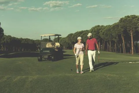 Couple walking on golf course Fotos Stock