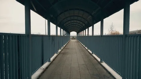 Couple walking hand-to-hand across the footbridge over highway Stock Footage 78353641