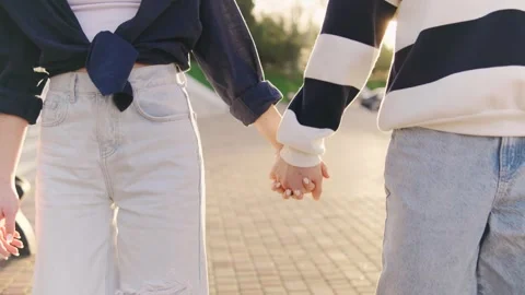 Couple walking hand in hand during sunset in a park, enjoying each others Stock Footage 314404898