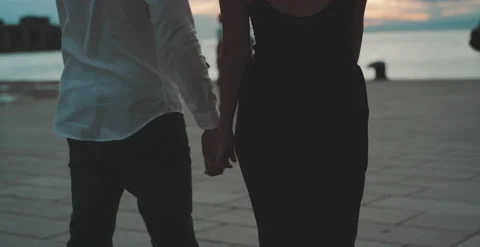 Couple walking hand to hand in front of the sea Stock Footage 204915658