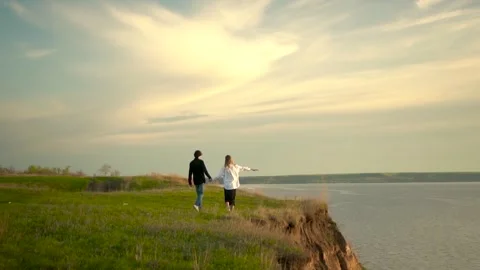A Couple Walking Hand in Hand Together Along a Scenic Clifftop at a Beautiful Vídeos de archivo 280866774