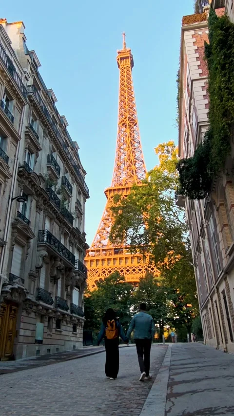 Couple walking hand in hand under the Eiffel Tower in Paris, France Stock Footage 347261280