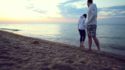 Couple walking holding hands on sunset at summer sea beach Stock Footage 136500889