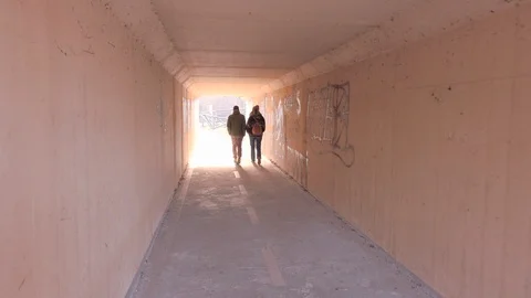 Couple walking inside a tunnel Stock Footage 102700636