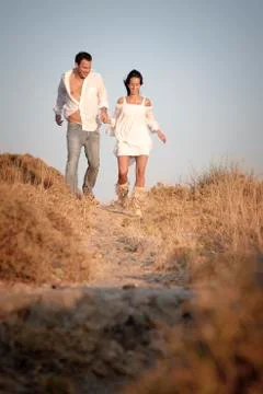 Couple walking a long a path together in a field. Stock Photos