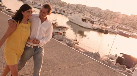 Couple walking by marina in sunset Stock Footage 43618294