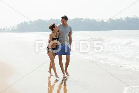 Couple Walking By The Ocean
