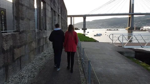 Couple walking with the Rande bridge on the background in Vigo (Galicia, Spai Stock Footage 124385251