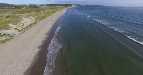 Couple walking on sandy beach at high tide - aerial flyby Stock Footage 78883367