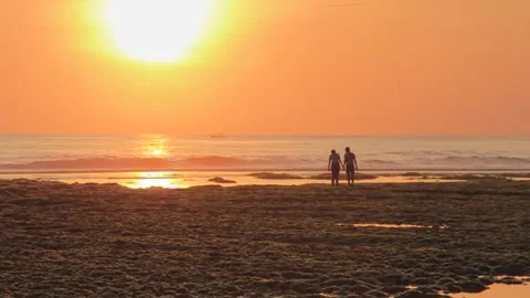 A couple walking in seashore taken at afternoon with twilight sky Stock Footage