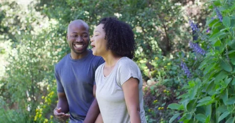 Couple walking, sharing laugh sparking chat, woman gesturing, man replying with Stock Footage 344386432