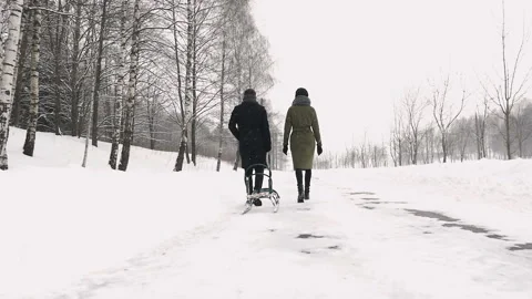 Couple walking in snow, pulling sledge. Slow mo Stock Footage 87845918