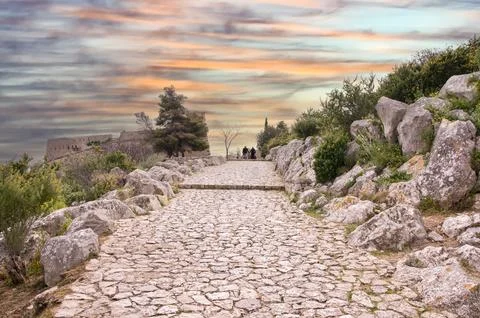 Couple walking on stone path at sunset .Greece Stock Photos