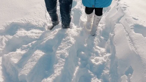 Couple walking through deep snow, in boots and jeans. Stock Footage 86571000