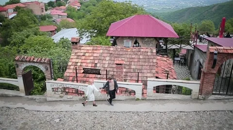 Couple walking through the old mountain town Stock Footage 64775711