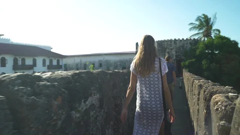 Couple walking through the passage of an ancient building Stock Footage 85777477