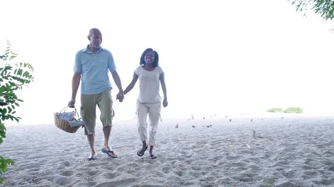 Couple walking through trees to beach. Stock Footage 88021852