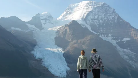Couple Walking Toward Mount Robson Glacier on Berg Lake Trail Stock Footage 323324548