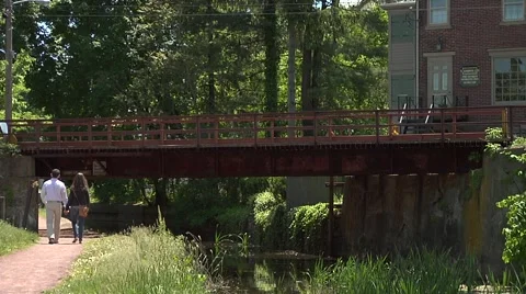 Couple Walking On Towpath Under Red Bridge Stock Footage 974629