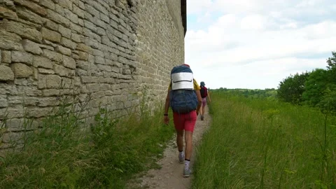 Couple walking the trail past the stone wall Stock Footage