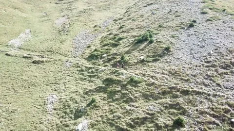 Couple walking in a valley trough the mountains Stock Footage 145421228