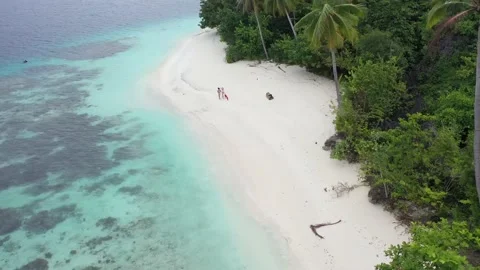 Couple Walking on White Sand Beach on an Island in Raja Ampat Adventure Stock Footage 197059121