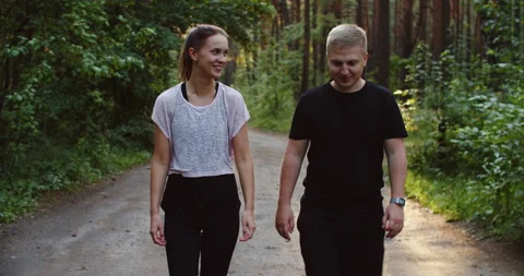The couple walks after jogging through the woods. A man and a woman are walking Stock Footage 210869684