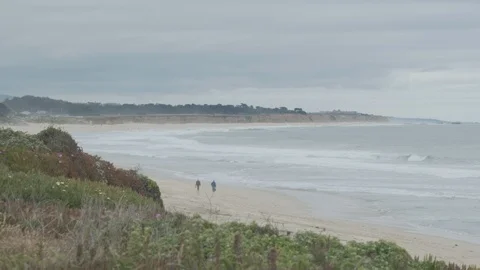 Couple walks down beach Stock Footage 93960190