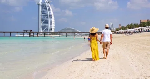 A couple walks down a beautiful beach in Dubai Stock Footage 266548334