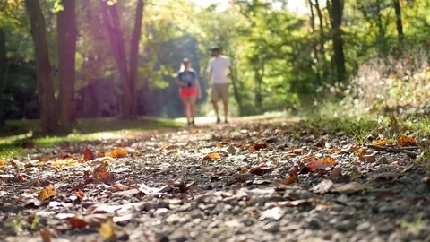 Couple walks down through a nature trail towards the camera in autumn Video stock 80326185