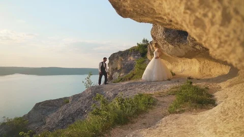 Couple walks out to ocean cliffs, takes in view together. Slow motion Stock Footage 107808499