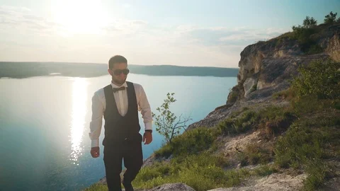 Couple walks out to ocean cliffs, takes in view together. Slow motion Stock Footage 107808604