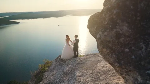 Couple walks out to ocean cliffs, takes in view together. Slow motion. Stock Footage 107809595