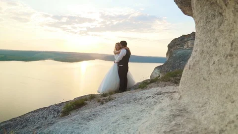 Couple walks out to ocean cliffs, takes in view together. Slow motion. Stock Footage 107812389