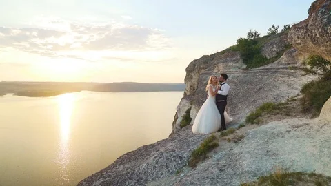 Couple walks out to ocean cliffs, takes in view together. Slow motion. Stock Footage 107812568