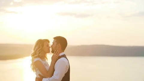 Couple walks out to ocean cliffs, takes in view together. Slow motion. Stock Footage 107813190