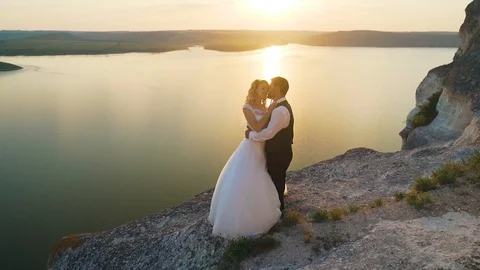 Couple walks out to ocean cliffs, takes in view together. Slow motion. Stock Footage 107813378