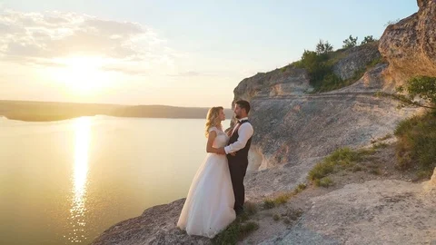 Couple walks out to ocean cliffs, takes in view together. Slow motion. Stock Footage 107813670