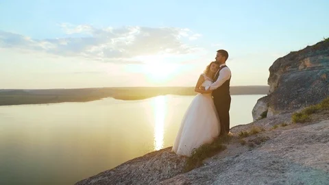 Couple walks out to ocean cliffs, takes in view together. Slow motion. Stock Footage 107814306