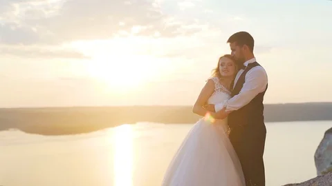 Couple walks out to ocean cliffs, takes in view together. Slow motion. Stock Footage 107814442