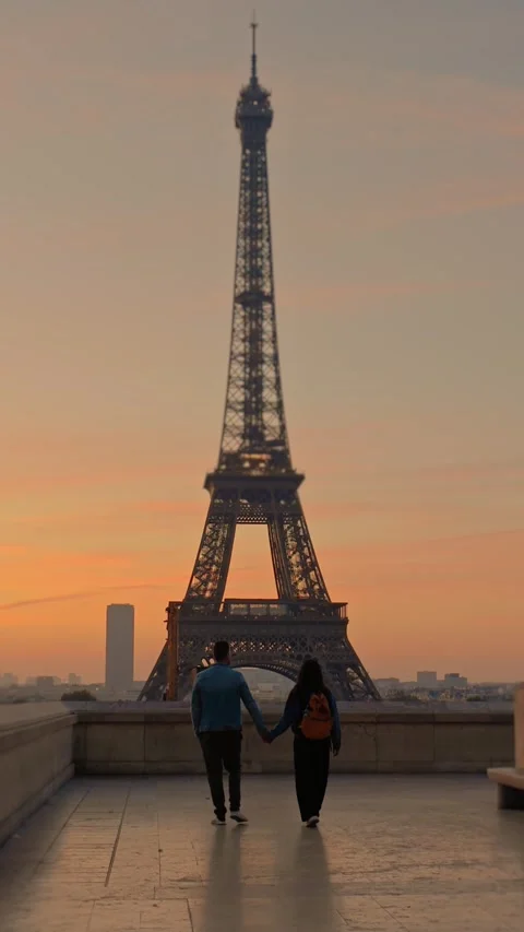 Couple walks toward the Eiffel Tower at sunset in Paris Stock-Footage 348650160