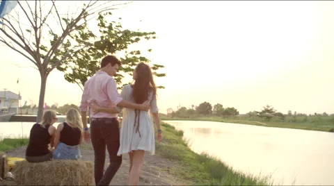A couple walks towards the sunset Stock Footage 63084745