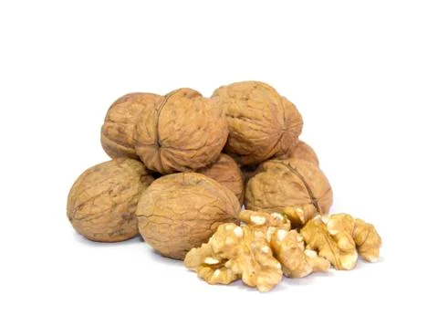 Couple of walnut kernels in front of pile of walnut shells isolated on white Stock Photos