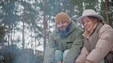 Couple is warming their hands by a campfire in the woods in winter Video stock 169504380