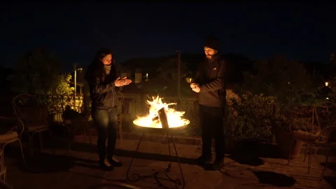 The couple warms up by the campfire Stock Footage 142550538