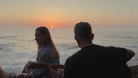 Couple Watching Atlantic Sunset While Playing Guitar. Stock Footage 327039417
